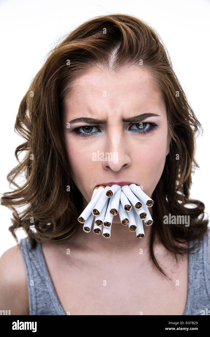 Böse Frau hält viele Zigaretten in den Mund Stockfoto