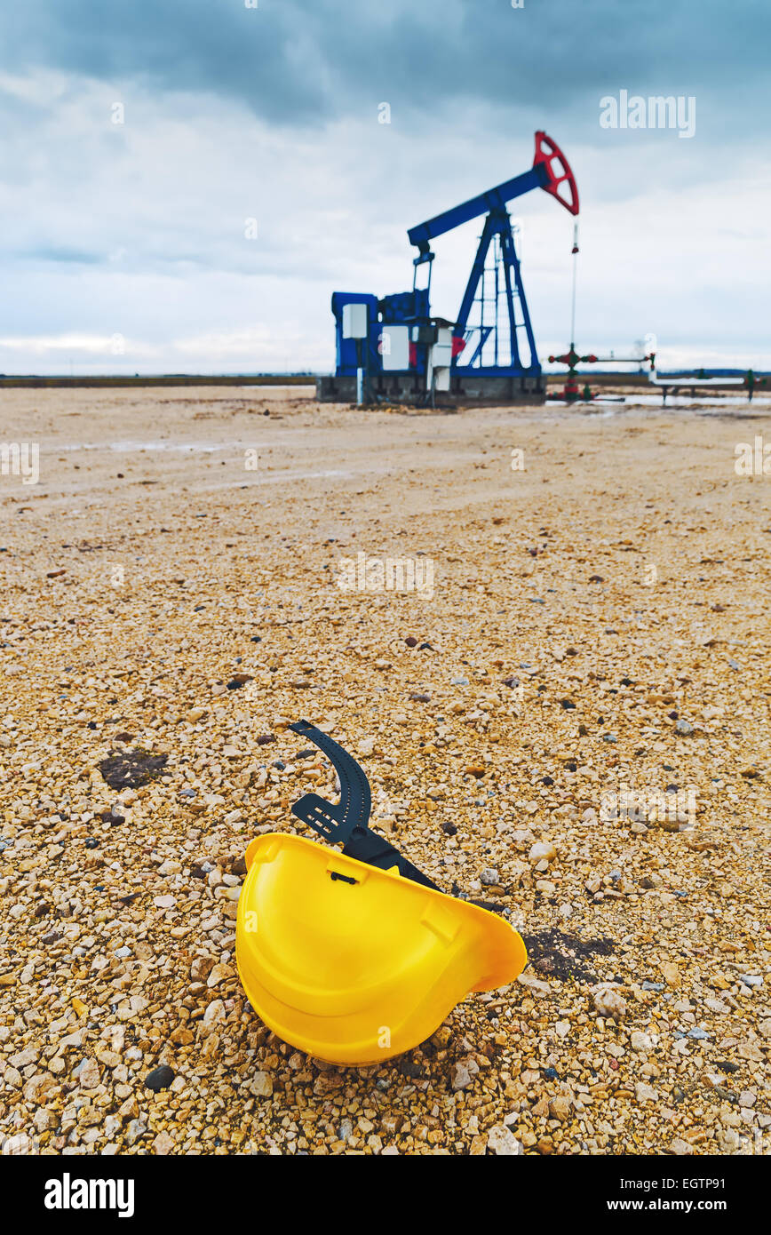 Schützende Helm und Bohrschwengels Ölpumpe auf Erdgas in das Feld Pumpen aus der Ölquelle. Stockfoto