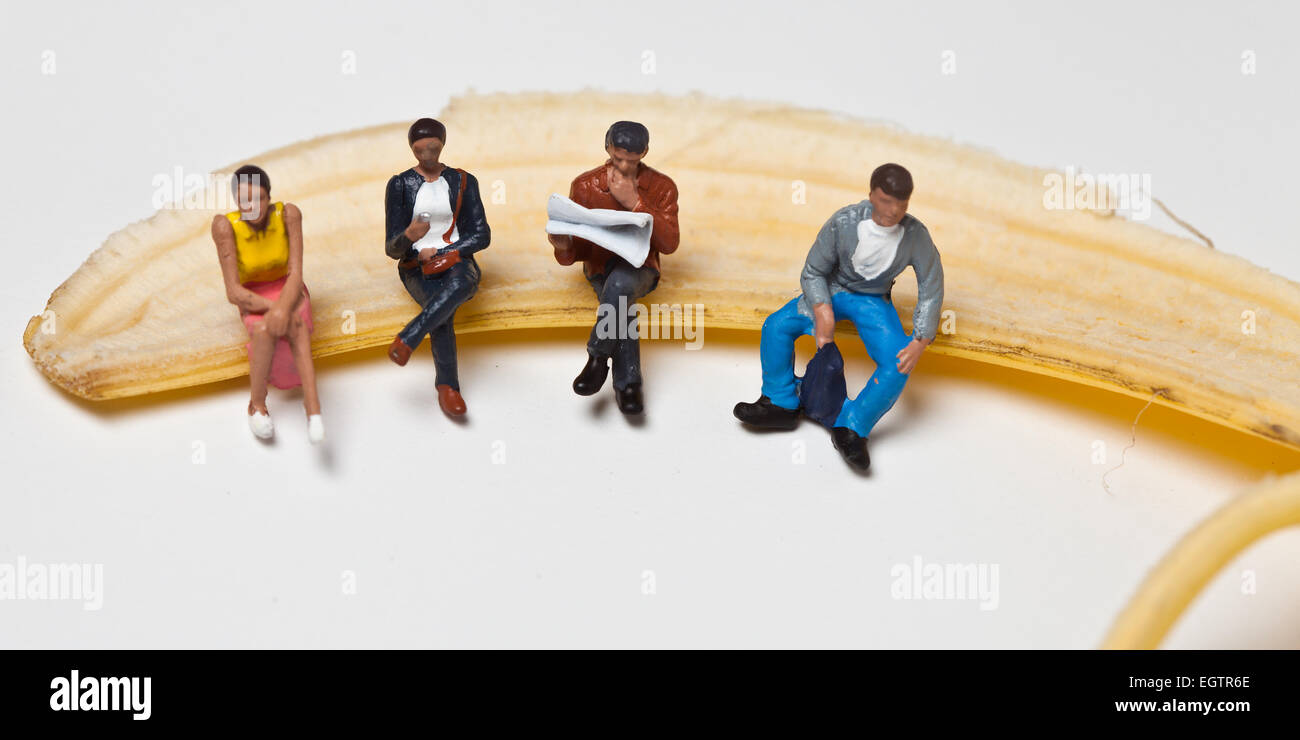 Miniatur-Menschen in Aktion in verschiedenen Situationen sitzt auf einem banan Stockfoto