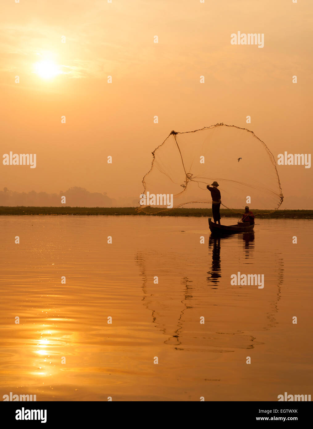 Ein Fischer wirft sein Netz bei Sonnenuntergang, Taungthaman See, Mandalay, Myanmar (Burma), Asien Stockfoto