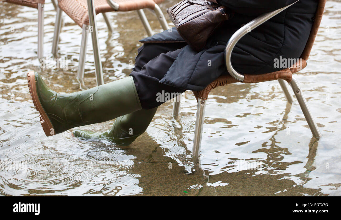 Close Up der Beine mit Stiefeln durch den hohen Wassergehalt. Diese Flut geschieht wenn es Hochwasser in Venedig, Italien. Stockfoto