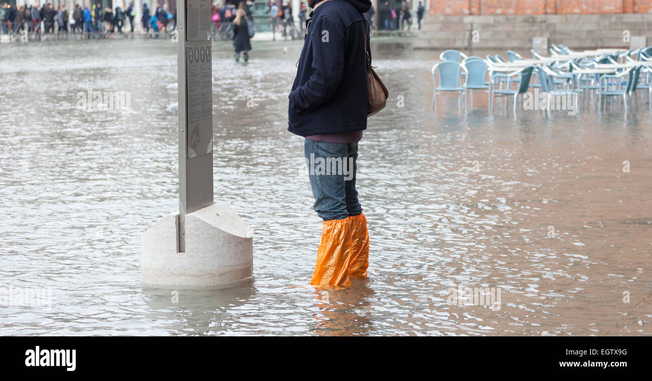Close Up der Beine mit Stiefeln durch den hohen Wassergehalt. Diese Flut geschieht wenn es Hochwasser in Venedig, Italien. Stockfoto