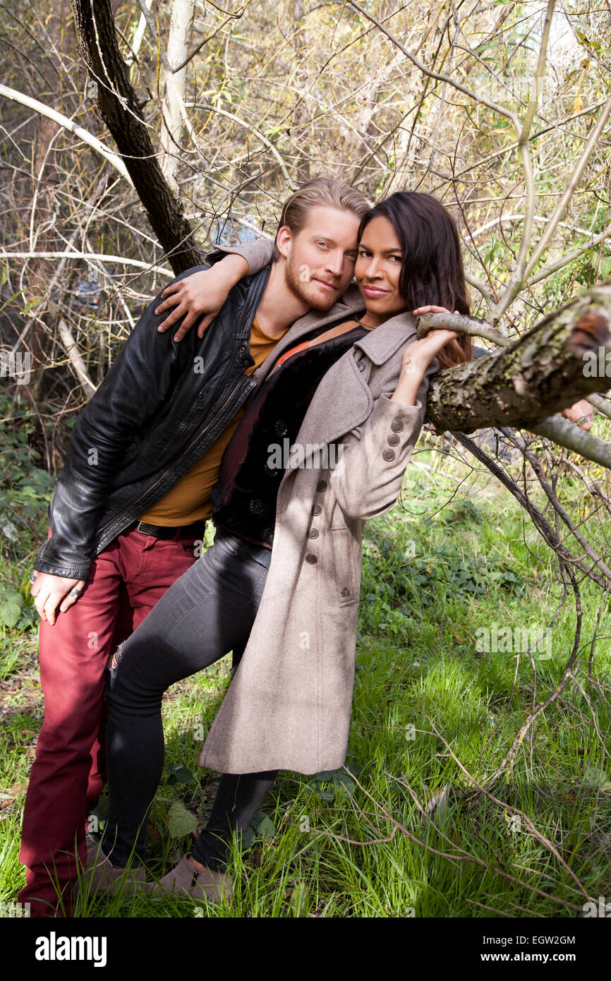 Mann an Frauen gegen einen Baum gelehnt. Stockfoto