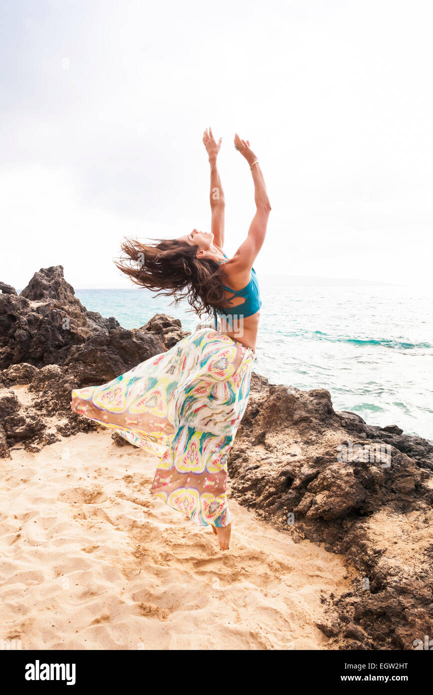 Frau, tanzen und springen am Strand. Stockfoto