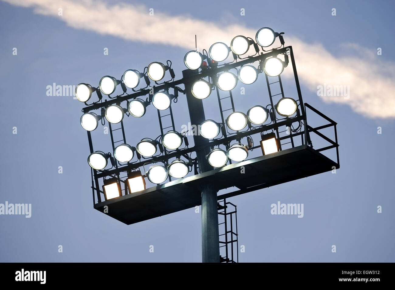 Fußball-Stadion-Scheinwerfer eingeschaltet bei Sonnenuntergang Stockfoto