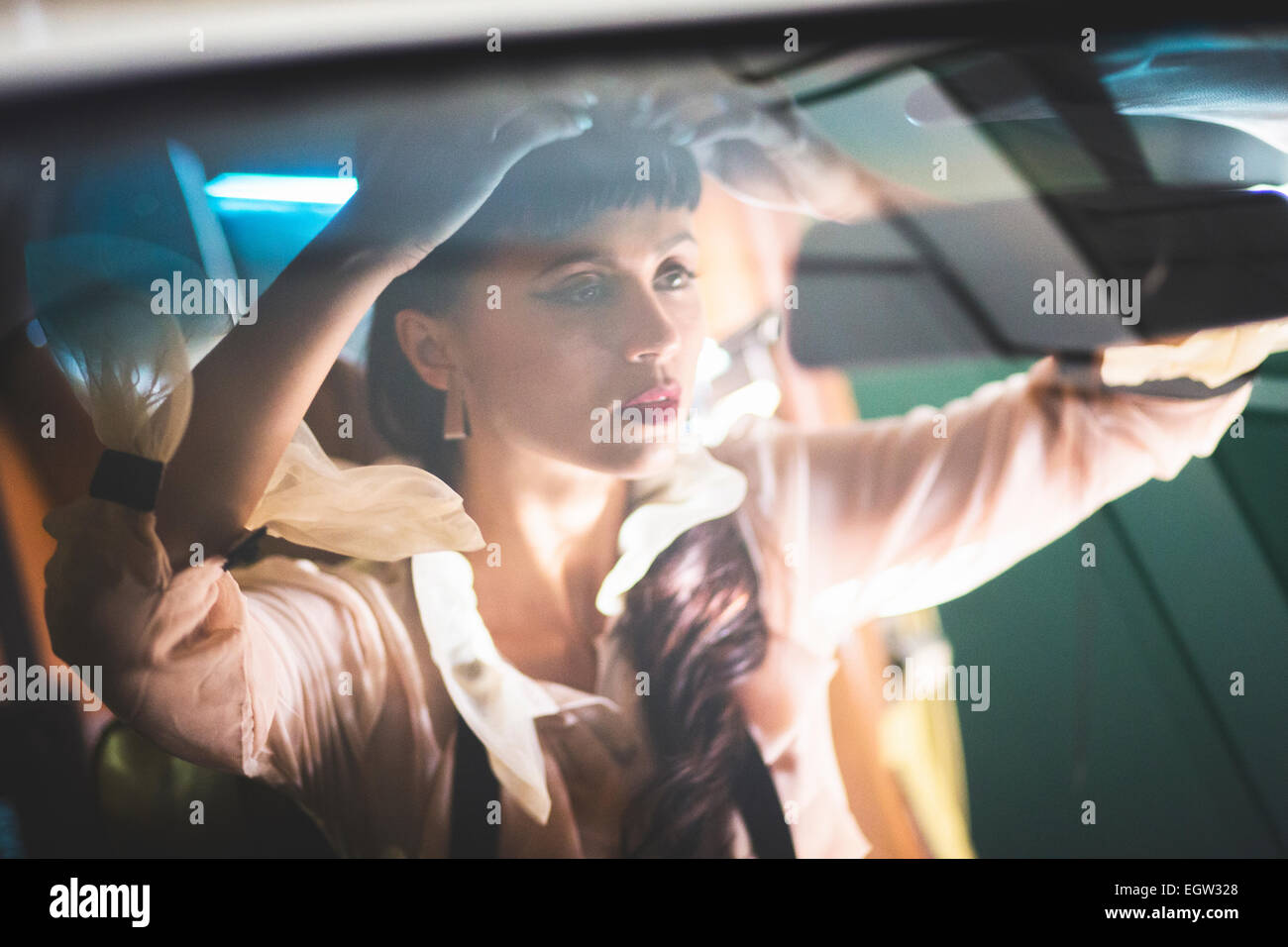 Frau ihr Haar im Auto befestigen. Stockfoto