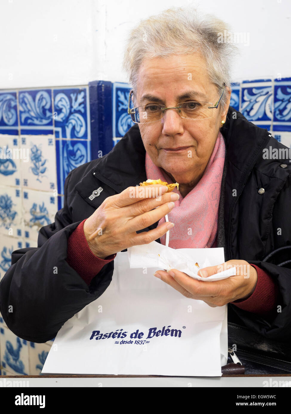 Applying Frau Essen ein Pastel de Belém in der Pastéis de Belém Bäckerei in Lissabon, Portugal Stockfoto