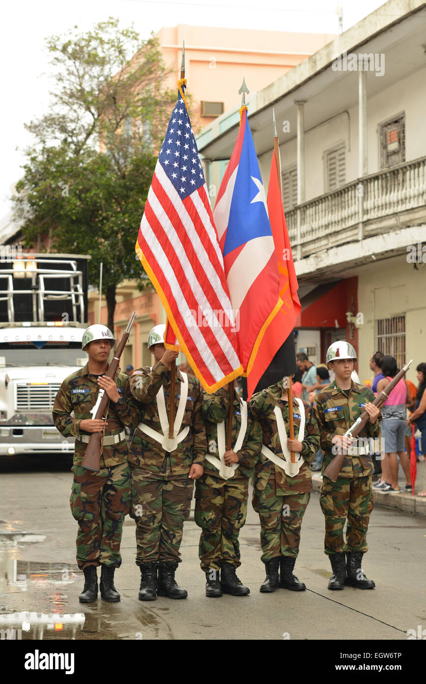 Militärische Schulkinder halten die Fahnen der USA, parade, Puerto Rico und Ponce während des Karnevals in Ponce, Puerto Rico-2015 Stockfoto