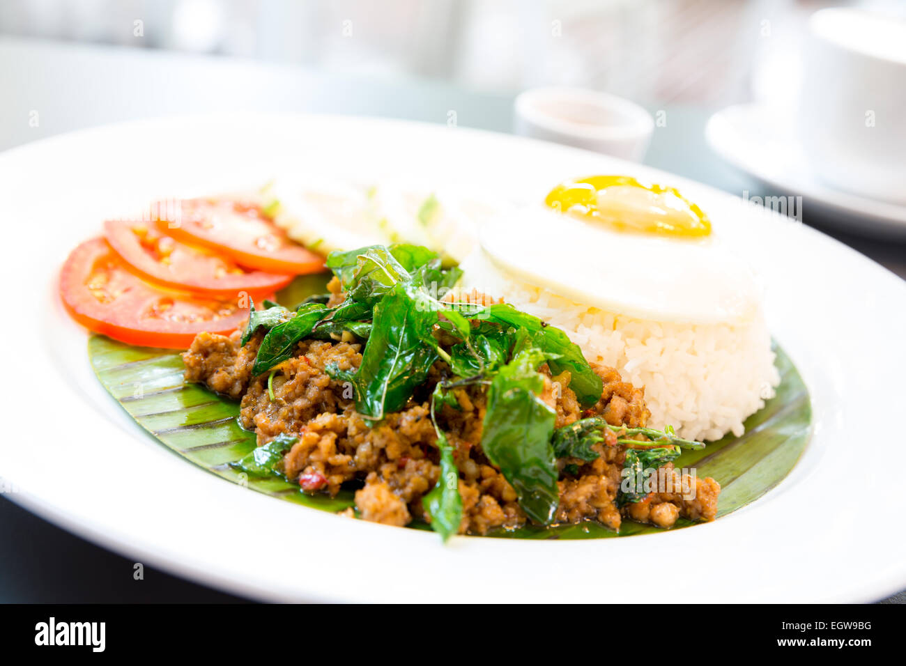 Gebratenes Schweinefleisch Basilikum Reis mit Ei, Tomate und Gurke Stockfoto