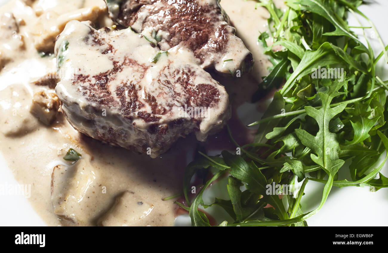 Steak in Sahne und Pilzen, serviert auf weißen Teller. Stockfoto