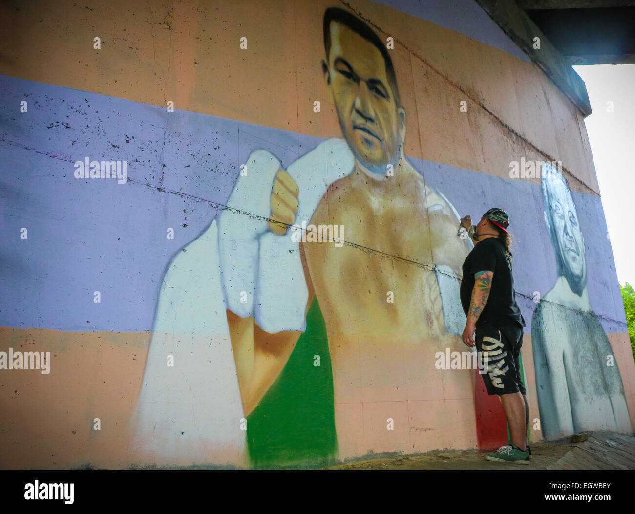 Ein Graffiti Künstler Farben ein Wandbild des bulgarischen Boxer Kubrat Pulev, aka The Cobra, an einer Wand unter einer Brücke zur Unterstützung der ungeschlagenen Schwergewichte-WM-Titel kämpfen gegen amtierende Weltmeister Wladimir Klitchko. Neben der Cobra ist ein Porträt des legenda Stockfoto