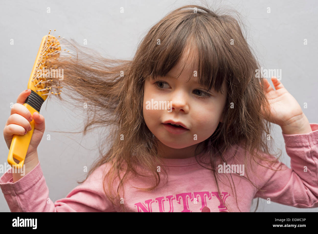 2 - Jahre altes Mädchen, Bürsten Sie ihr Haar Stockfoto