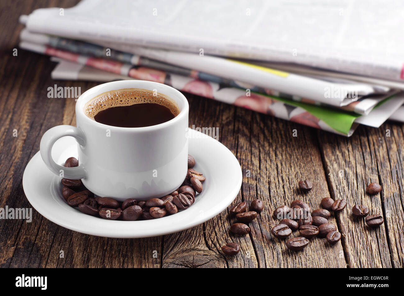 Tasse Kaffee und Zeitung auf alten Holztisch Stockfoto