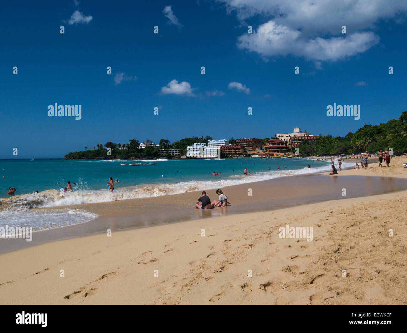 Blick entlang der beliebten öffentlichen Strand Playa de Sosua Dominikanische Republik Menschen Urlaub an schönen Winter Tag unberührten Sandstrand Stockfoto