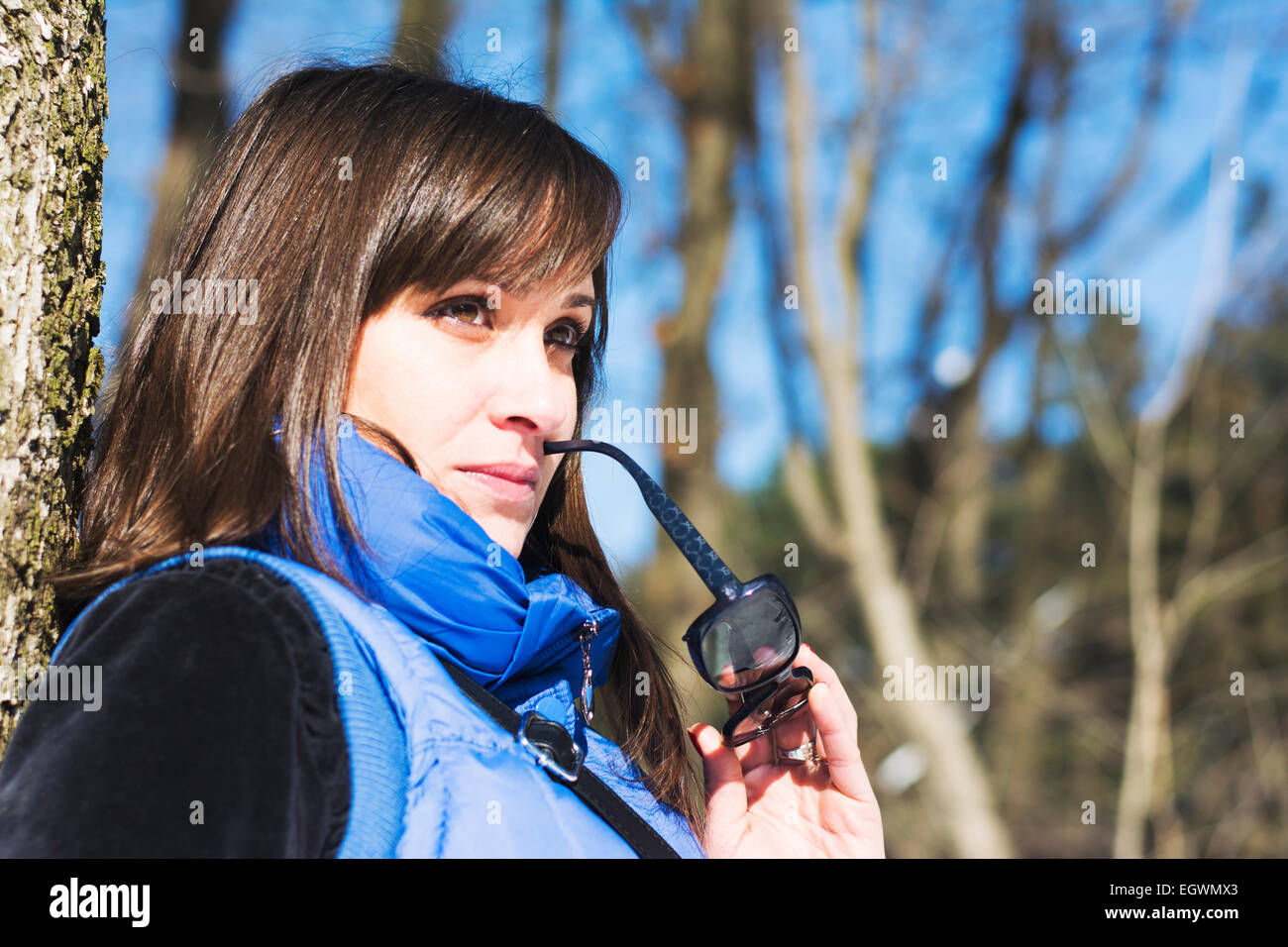 Hübsche Frau posiert im Wald im Winter halten Sie Sonnenbrillen Stockfoto