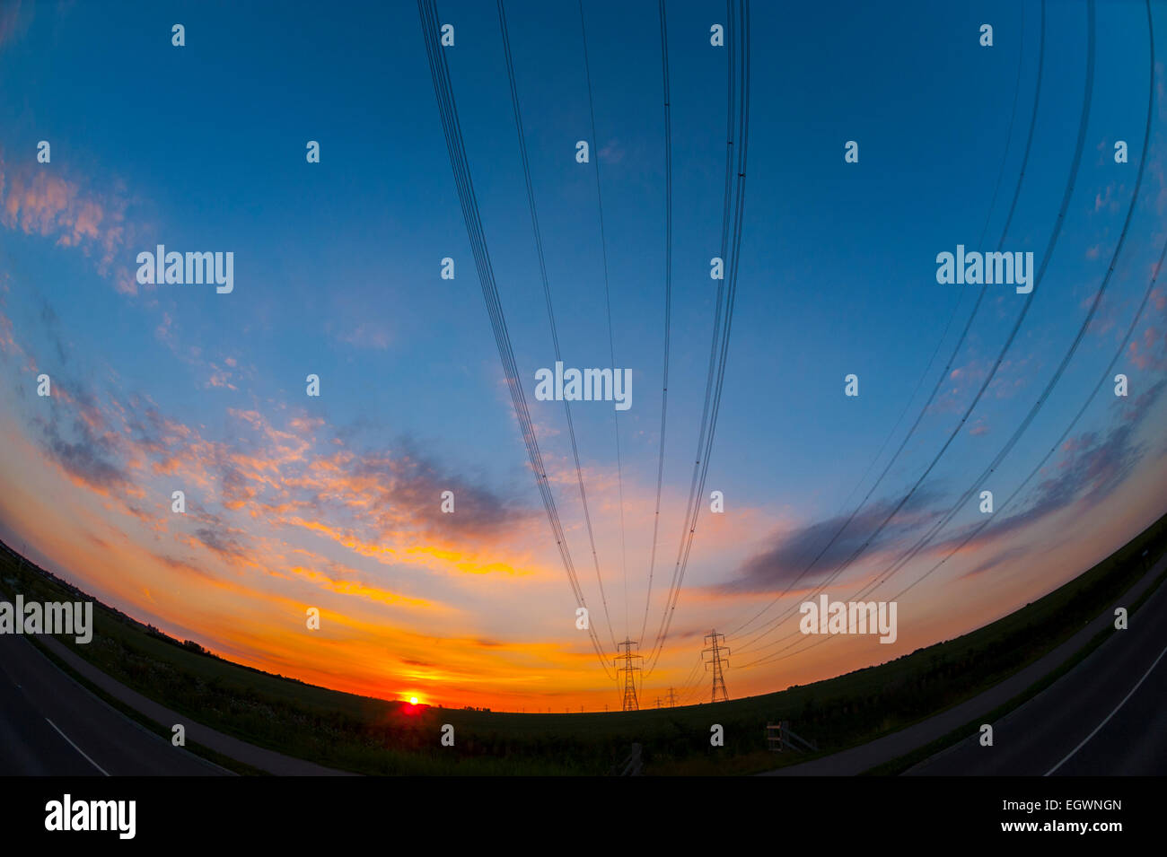 Stromleitungen bei Sonnenuntergang in der Nähe von Kraftwerk Kingsnorth Kent. Stockfoto