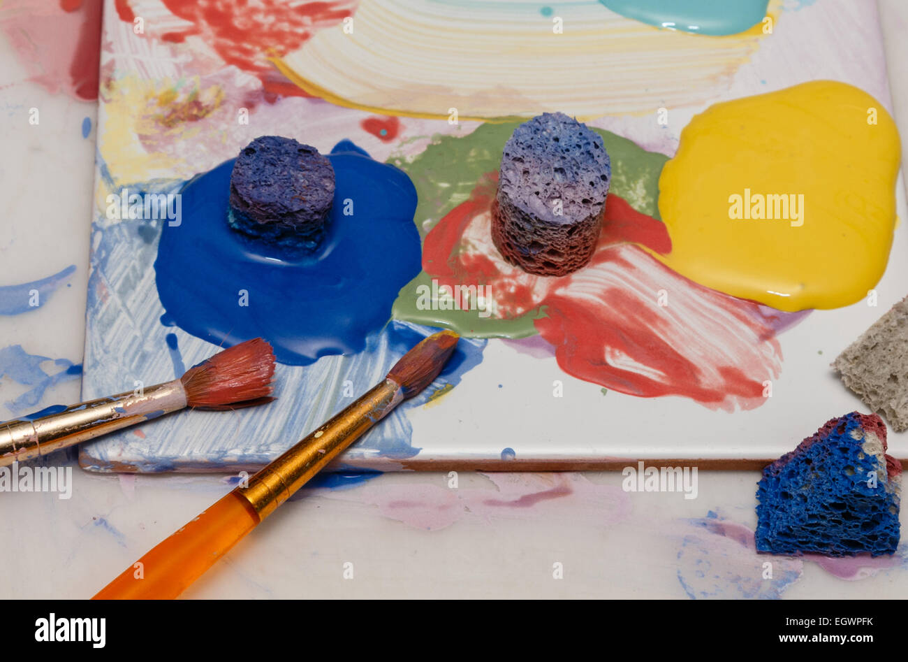 Künstler Pinsel Farben und Schwamm auf eine Kachel verwendet als Farbe palette Stockfoto