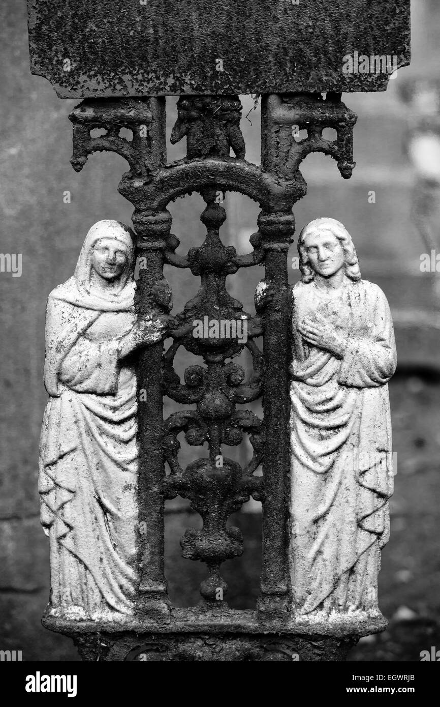 Detail von einer alten Eisernen Kreuz auf dem Friedhof Hasselt Monochrom, 2 Heiligen hält das Kruzifix Stockfoto