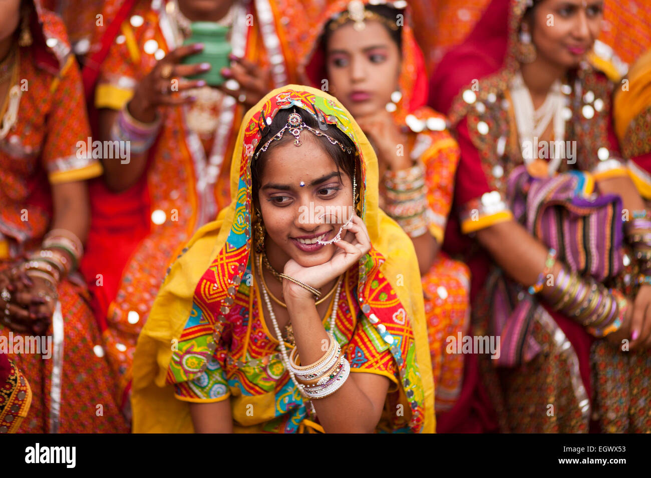 Junge Frau in ihrer typischen farbenfrohen Tracht auf dem Kamel Messe Pushkar Mela, Pushkar, Rajasthan, Indien, Asien Stockfoto