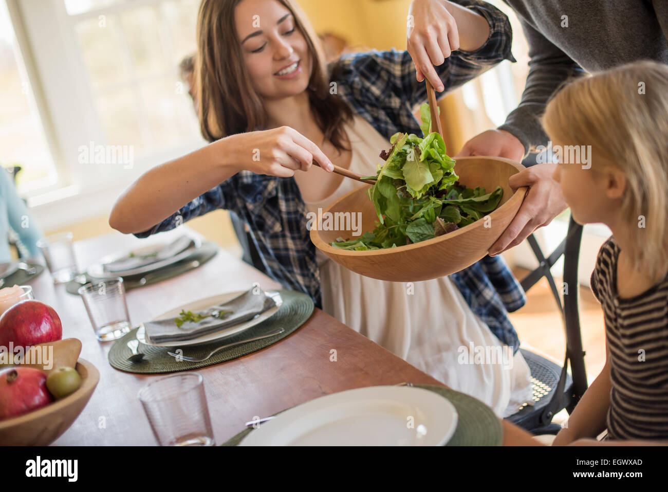 Eine junge Frau, die sich dazu Salat an einem Tisch. Stockfoto