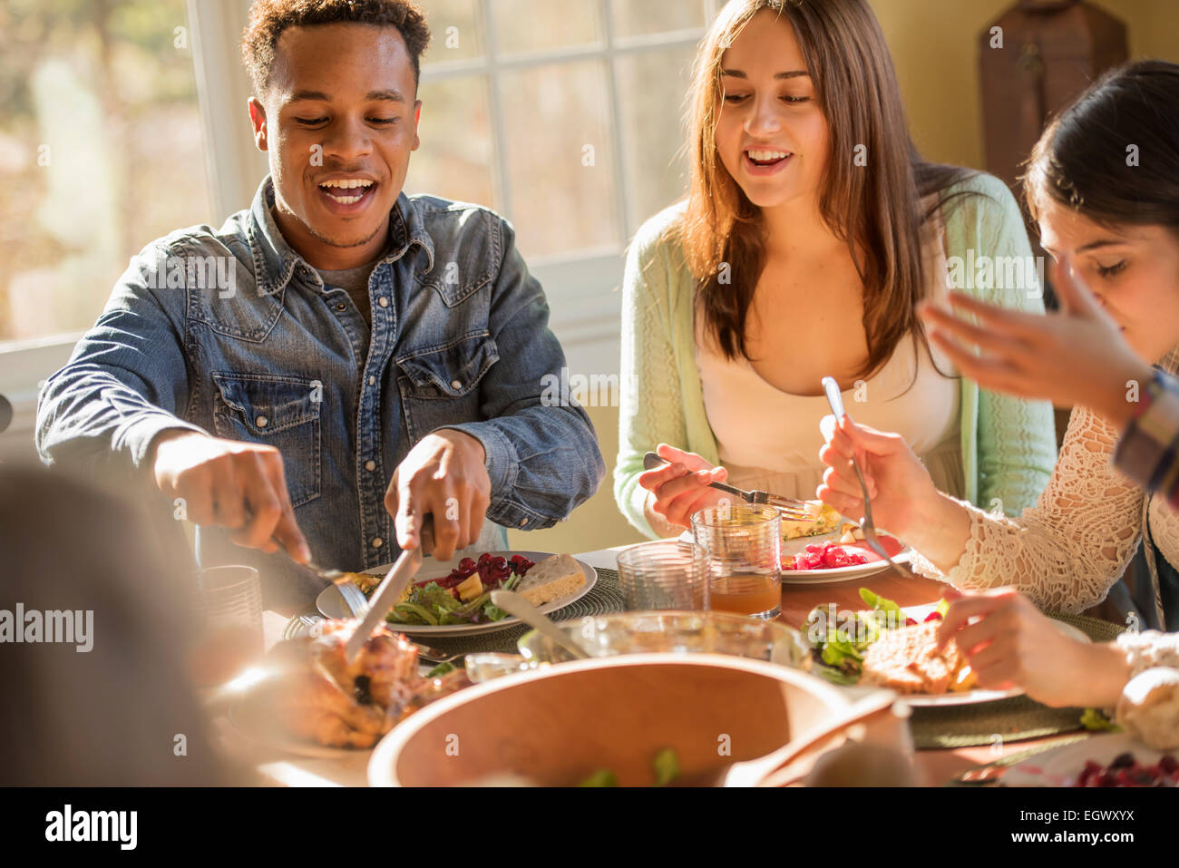 Eine Gruppe von Menschen, Erwachsene und Kinder, sitzen um einen Tisch für eine Mahlzeit. Stockfoto