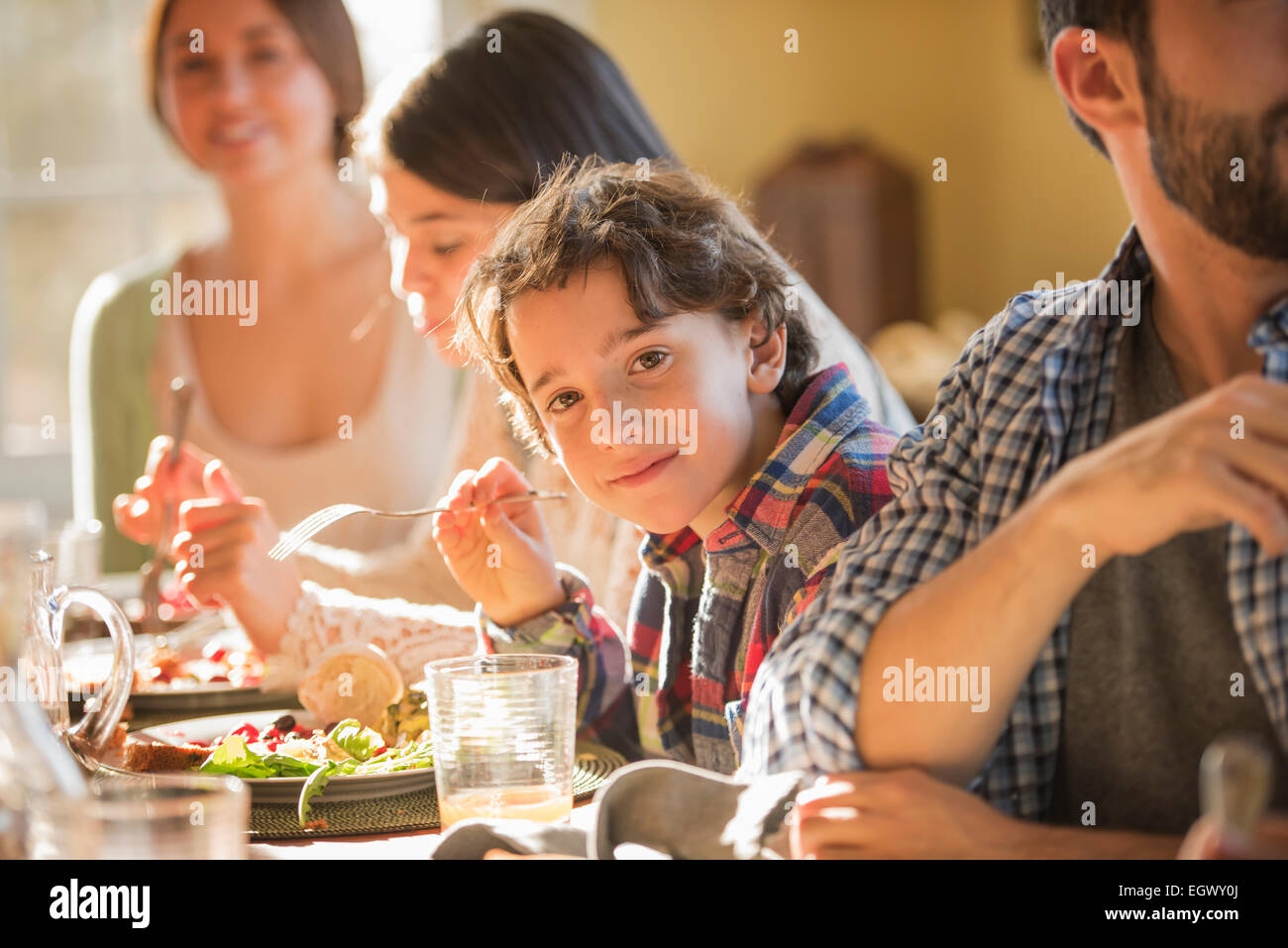 Eine Gruppe von Menschen, Erwachsene und Kinder, sitzen um einen Tisch für eine Mahlzeit. Stockfoto