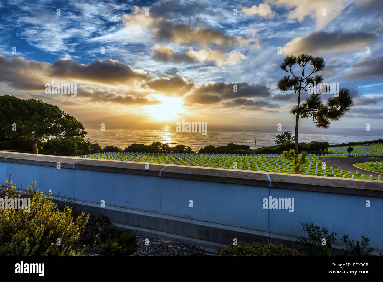 Die untergehende Sonne durch die Wolken über dem Pazifischen Ozean. Blick vom Fort Rosecrans National Cemetery, San Diego, Kalifornien, Vereinigte Stockfoto