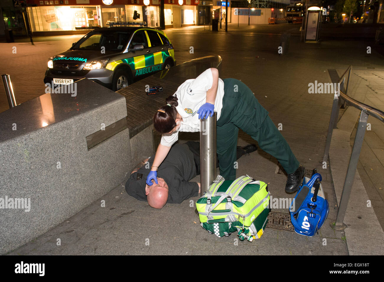 Sanitäter Krisenreaktions-Behandlung von ein Mann, der gefunden wurde stürzte von einem Mitglied der Öffentlichkeit in Birmingham Stadtzentrum entfernt. Stockfoto