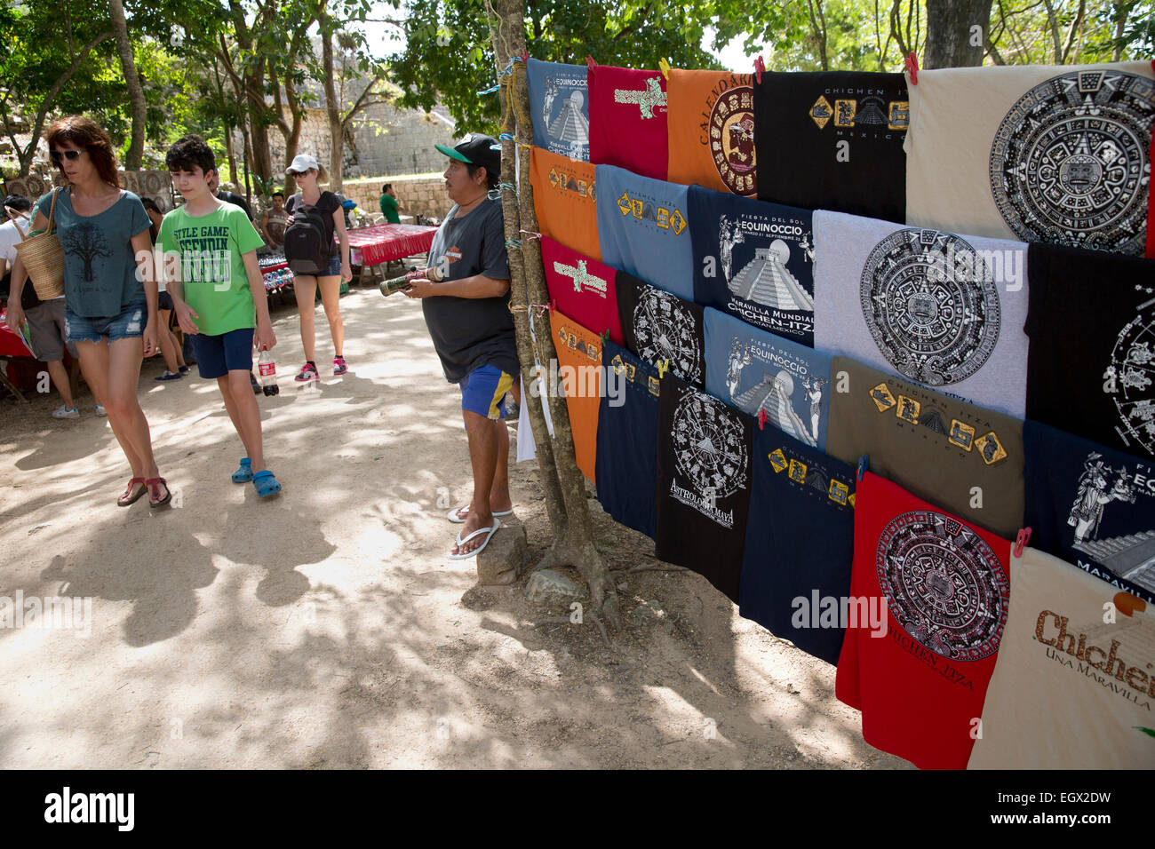 Touristen gehen vorbei an eine Souvenir-Verkäufer bei den Maya-Ruinen von Chichen Itza, Yucatan, Mexiko Stockfoto