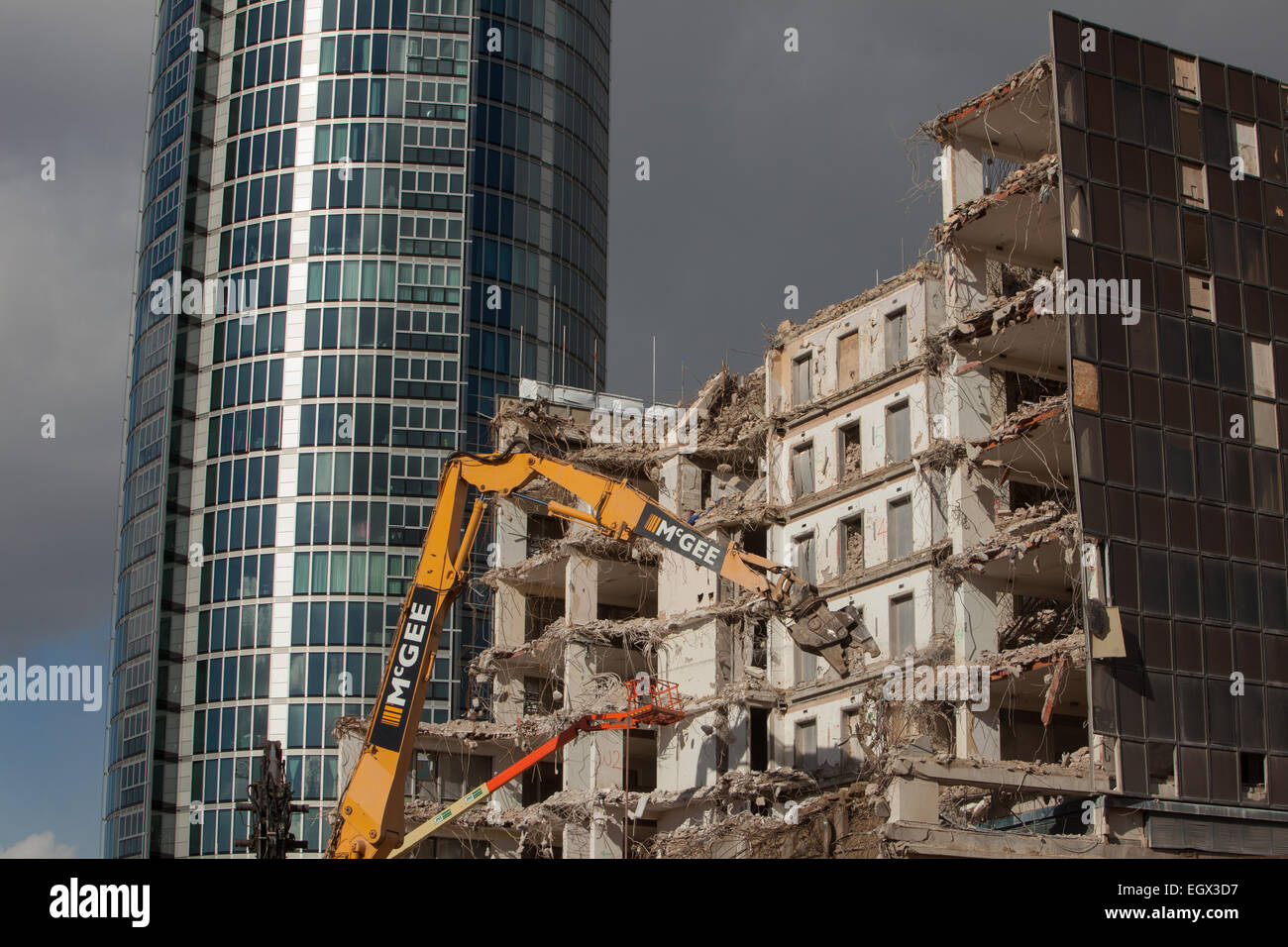 Abriss und Neubau mit mechanischen Digger im Vordergrund Stockfoto