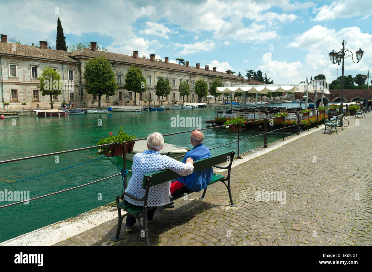 zwei ältere Männer genießen den Blick in den malerischen Hafen von Peschiera del Garda. Stockfoto