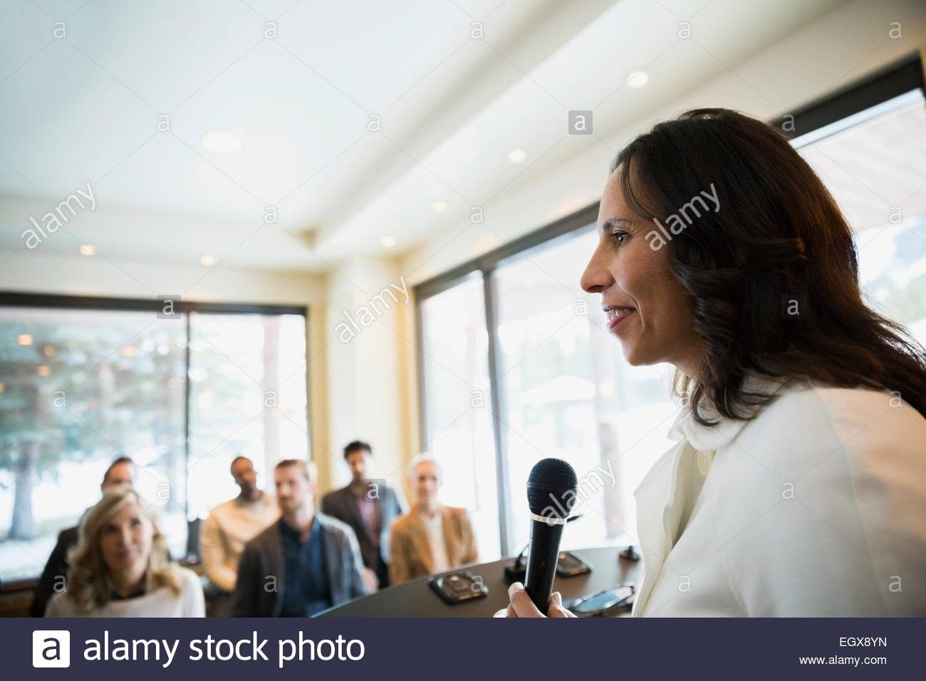 Geschäftsfrau mit Mikrofon führende Konferenz Stockfoto