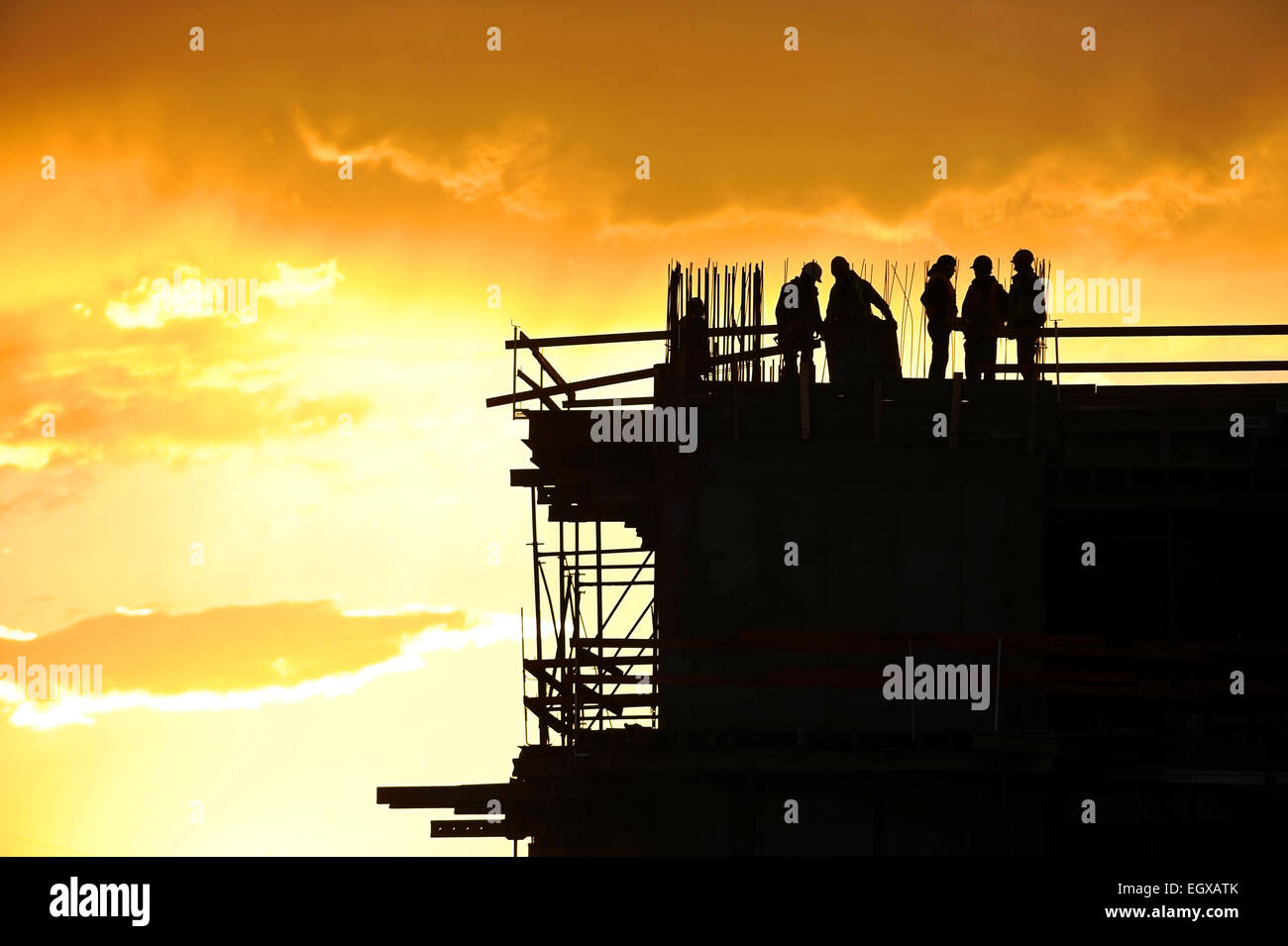 Bau-Arbeiter-Silhouetten auf einer Baustelle bei Sonnenuntergang Stockfoto