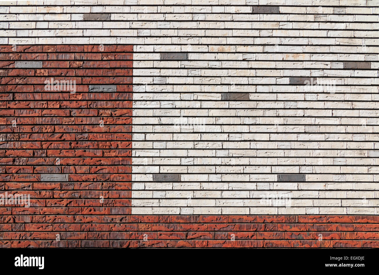 Weiß und orange roten Backsteinmauer mit unregelmäßiger Oberfläche, durchsetzt mit einigen grauen Steinen Stockfoto