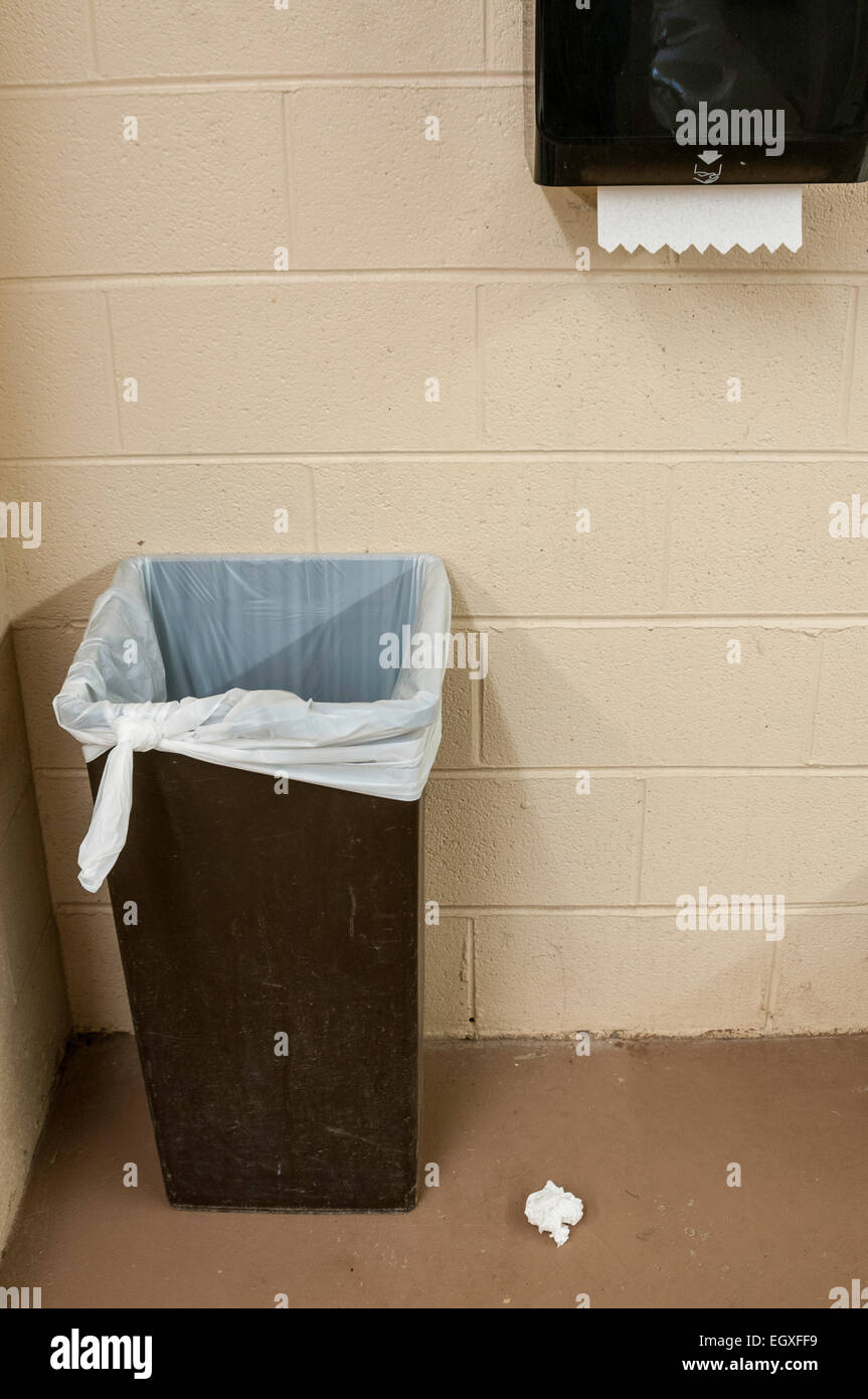 Eine Toilette Mülleimer mit einem Papiertuch auf den Boden neben ihm geworfen. Stockfoto