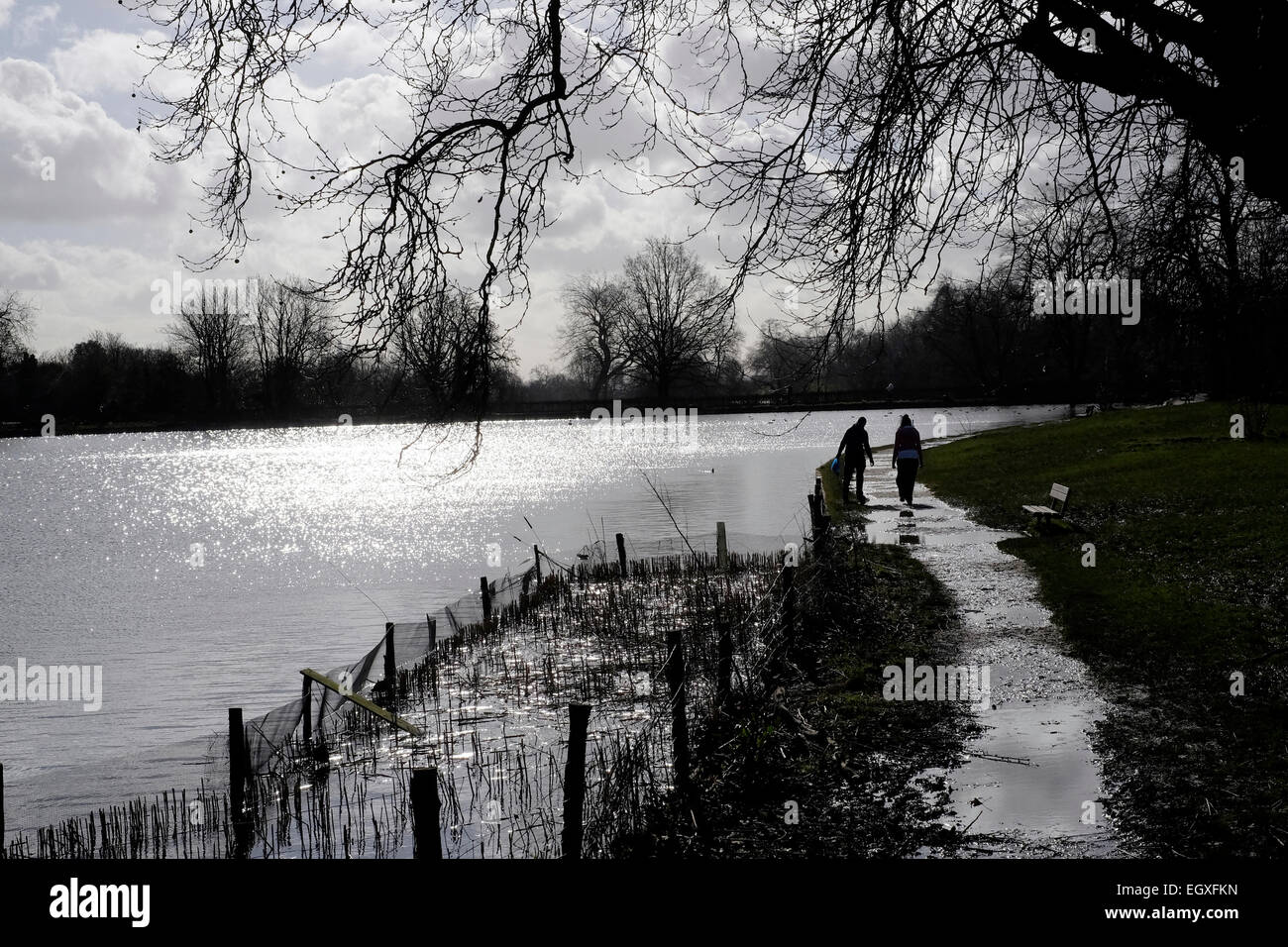 Ein paar in der Silhouette, die zu Fuß von Hampstead Heath Teiche, London Stockfoto