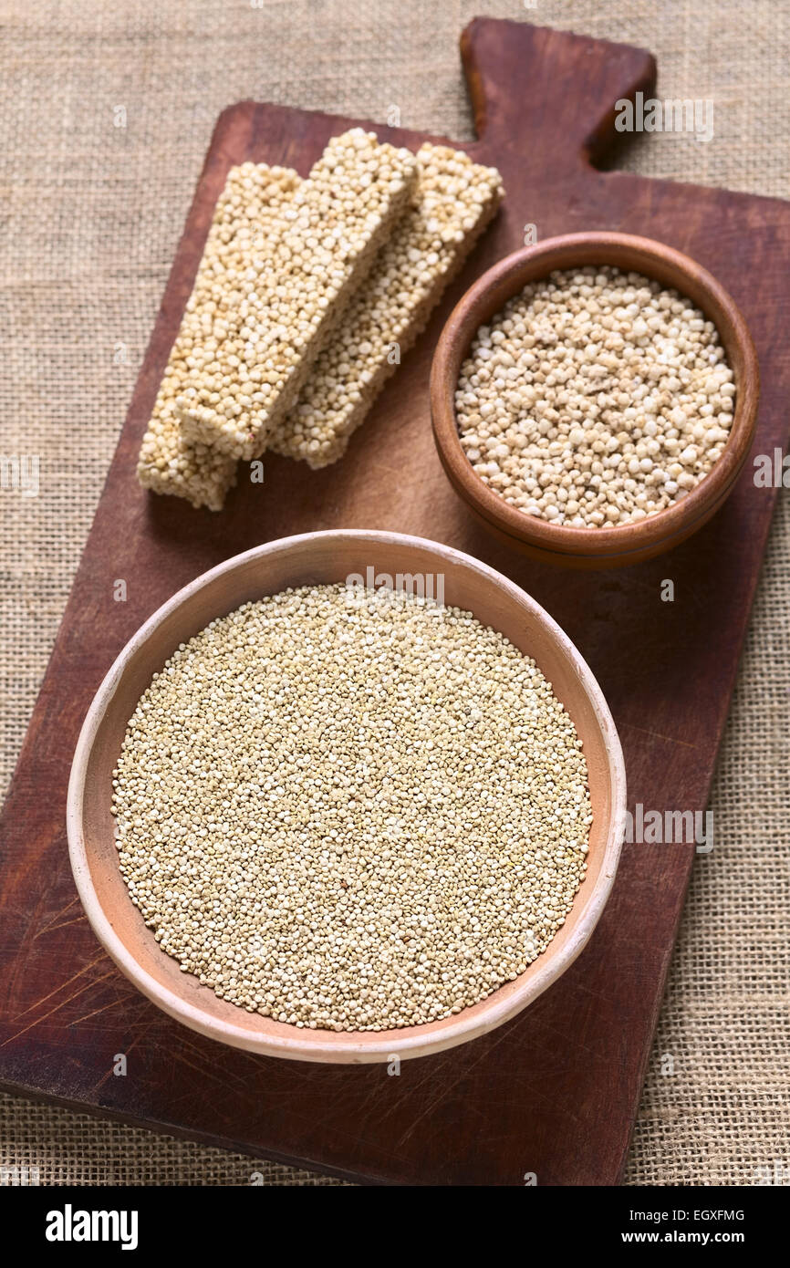Overhead Schuss von rohen weißen Quinoa (Chenopodium Quinoa lat.) Getreide Samen in Schüssel mit geplatzten Quinoa Getreide und Quinoa Müsliriegel Stockfoto