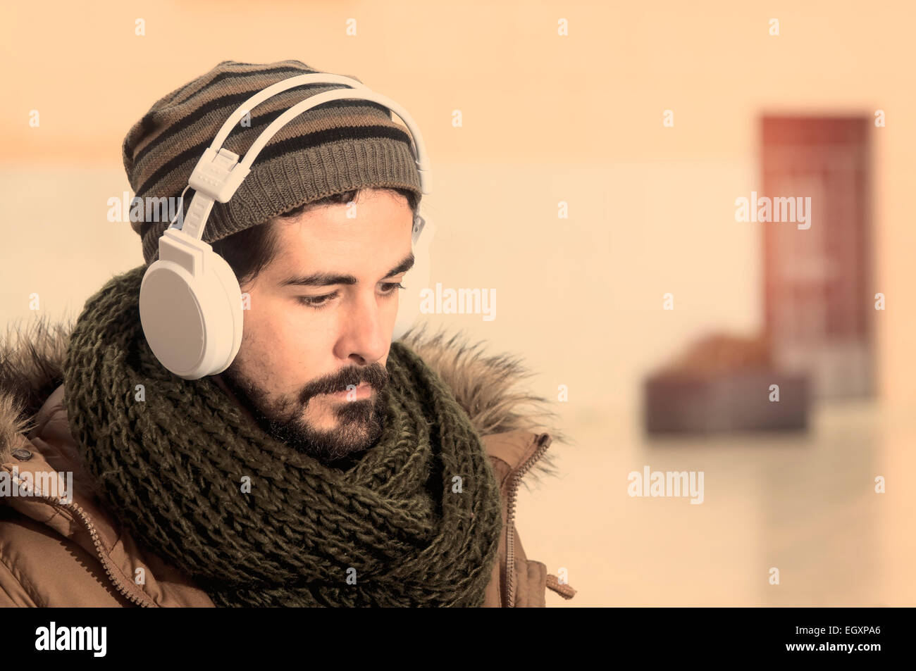 ein junger Mann hört Musik in einem städtischen Bild des modernen Lebensstils Istagram getönt Stockfoto