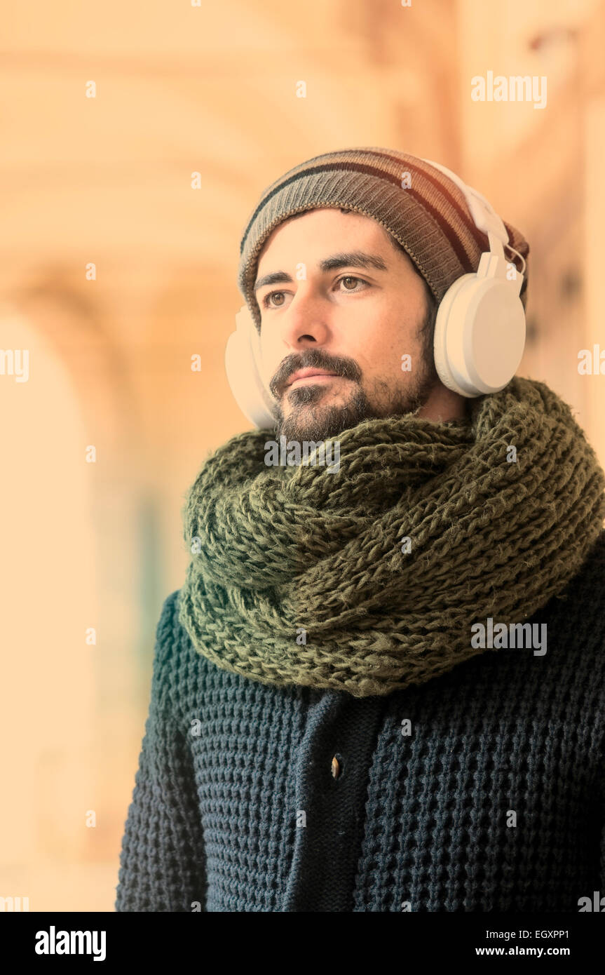 junge stilvolle bärtiger Mann anhören von Musik in einer mediterranen Stadt in Instagram Töne Stockfoto