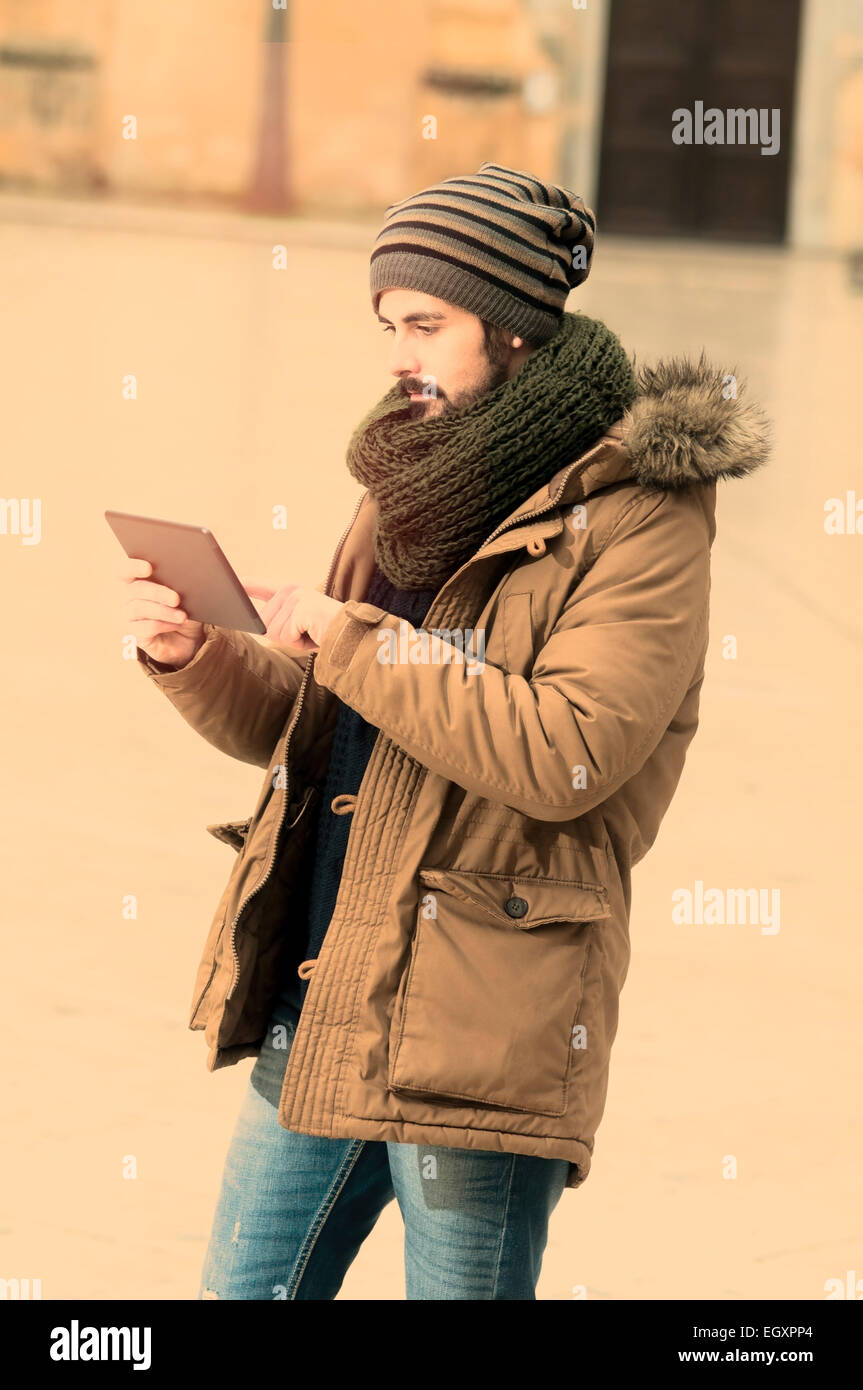 Hipster junge während der Verwendung einer Tabletts in städtischen Gebieten in Instagram Tönen Stockfoto