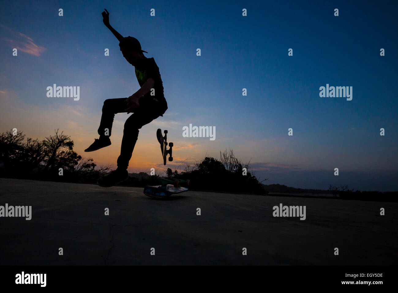 Mann springt auf Skateboard im Sonnenuntergang. Bali.Indonesia. Stockfoto