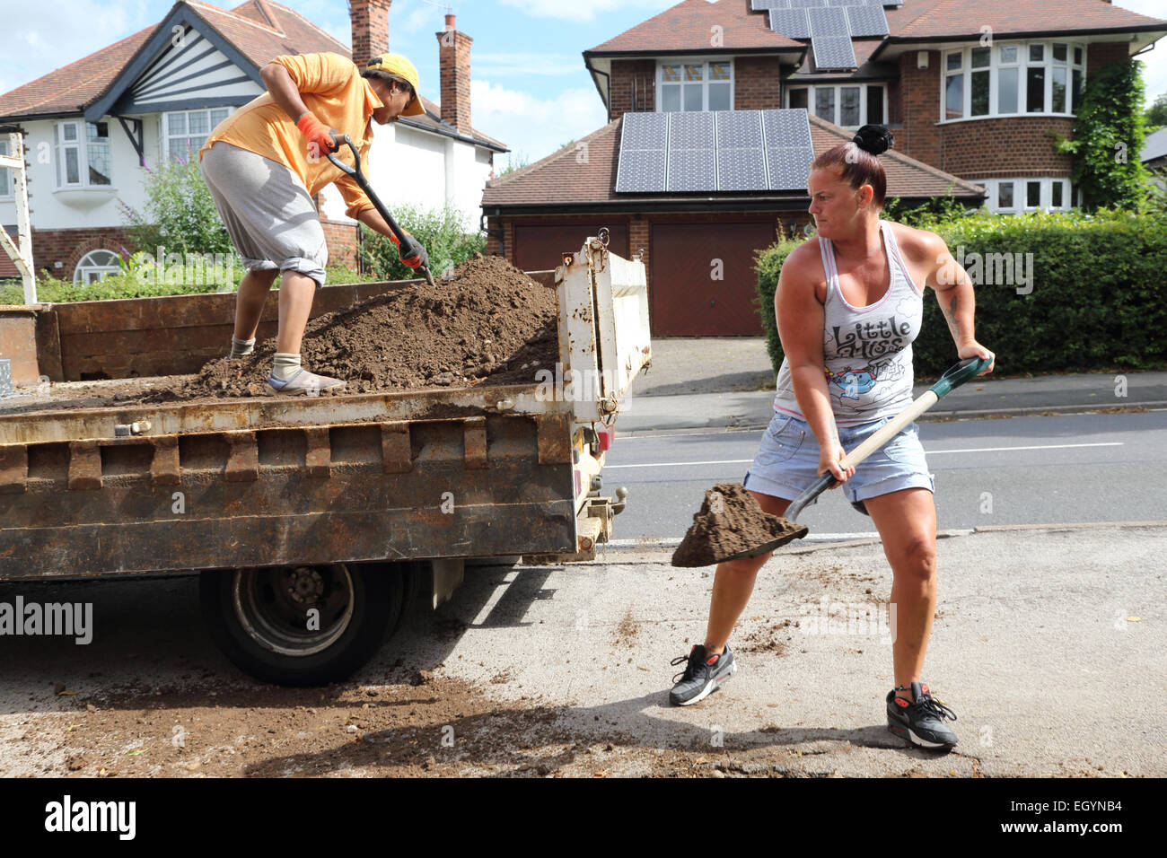 Frauen, die Schaufeln Erde in LKW Stockfoto