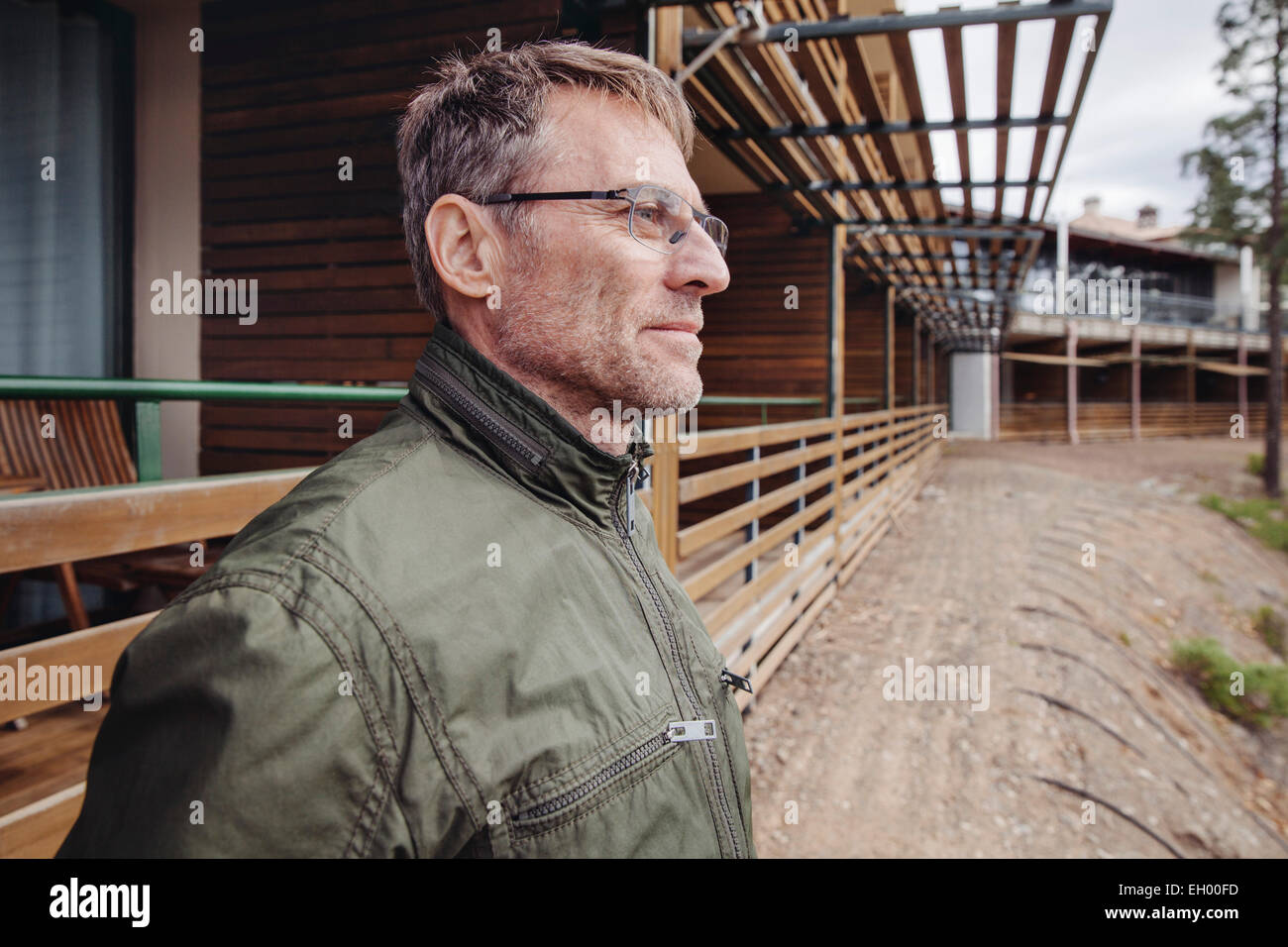 Reifer Mann vor Holzgebäude Struktur Stockfoto