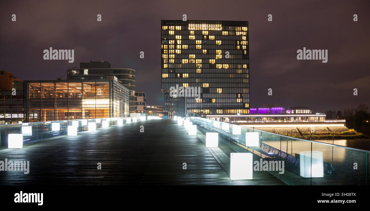 Deutschland, Düsseldorf, Medienhafen, Hyatt Regency Hotel und Fußgängerbrücke in der Nacht Stockfoto