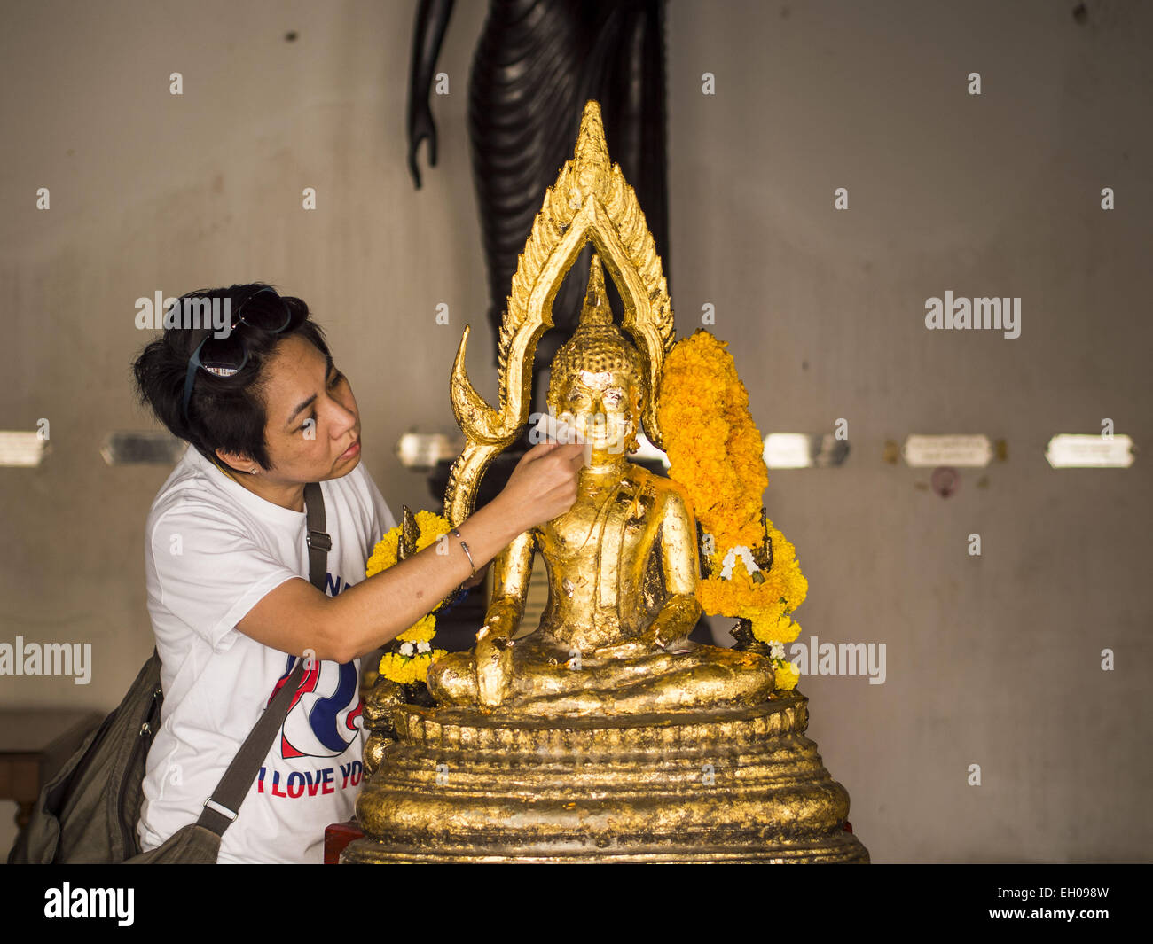 Bangkok, Thailand. 4. März 2015. Eine Frau gilt eine Statue des Buddha im Wat Benchamabophit Blattgold auf Makha Bucha-Tag. Makha Bucha-Tag ist ein wichtiger buddhistischen Heiligen Tag und Feiertag in Thailand, Kambodscha, Laos und Myanmar. Viele Menschen gehen zum Tempel Verdienst ausgerichteten Aktivitäten auf Makha Bucha-Tag durchführen. Wat Benchamabophit gehört zu den beliebtesten buddhistischen Tempel in Bangkok. Bildnachweis: Jack Kurtz/ZUMA Draht/Alamy Live-Nachrichten Stockfoto