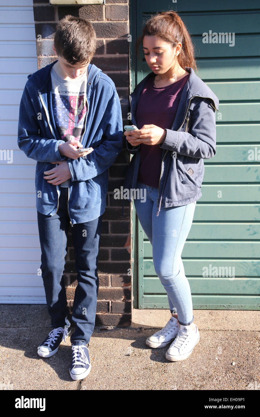 Jugendliche mit dem Handy in der Nähe von Wohnungen - Modell veröffentlicht Stockfoto