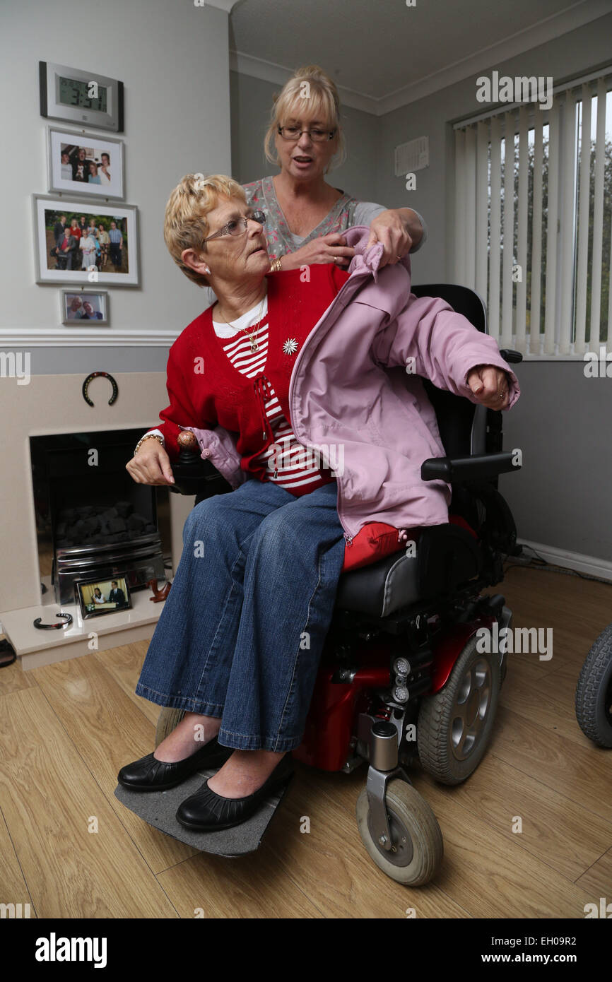 Pflegeperson setzen Rollstuhl Benutzer Mantel - Modell veröffentlicht Stockfoto