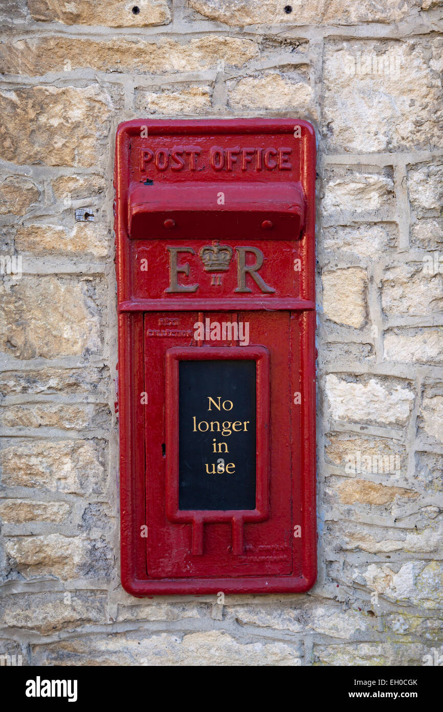 Kleine rote Briefkasten nicht mehr in Verwendung in Steinmauer, Castle Combe, Wiltshire, England, Großbritannien Stockfoto