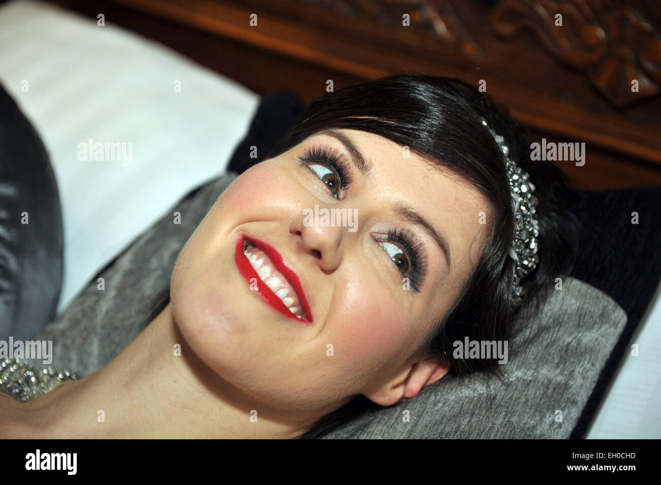 Frauen mit vollen Make-up liegen auf einem Kissen lächelnd Modell veröffentlicht Stockfoto