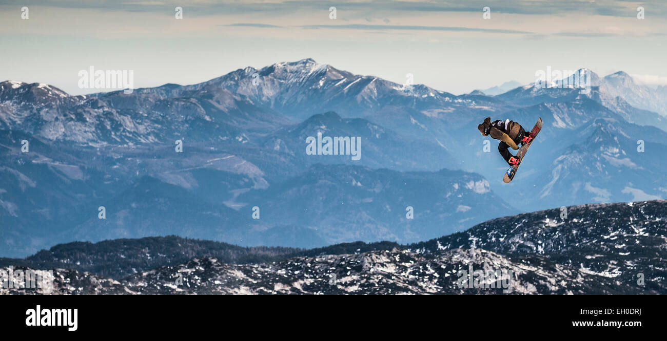 Ein Snowboarder, einen Grab mit einem Spin in den Funpark auf dem Dachstein-Gletscher in Österreich durchführen. Stockfoto